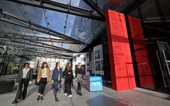 A photograph of a group of women walking towards Tate Liverpool + RIBA North