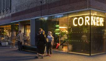 People standing outside industrial-themed bar at night