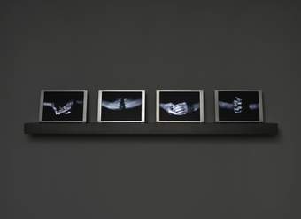 Four photographs of hands on a grey shelf against a grey wall