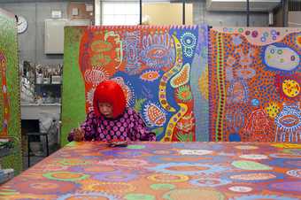 Photograph of Yayoi Kusama working in her studio