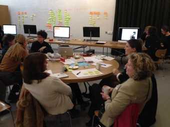 People sitting around a table covered in paper and notes