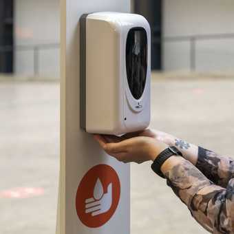 Person using a sanitiser dispenser.