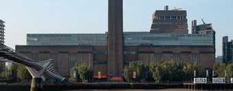 A tall tower in front of a large brick building