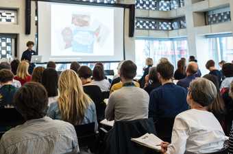 An audience listens to a presentation at Experiments in Practice, 2017