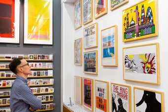 Visitor looking at prints in the Turbine Hall shop at Tate Modern