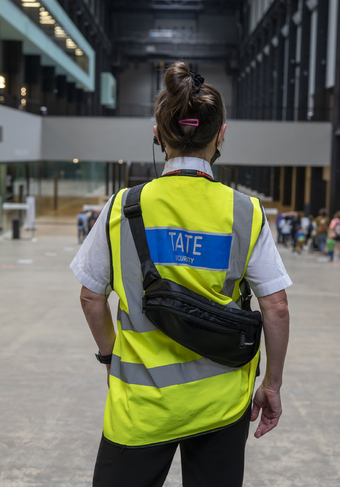 Security staff wearing a yellow jacket